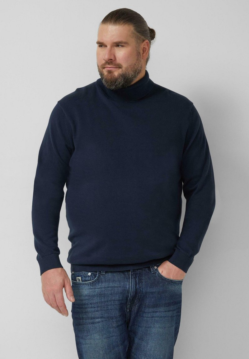 Marineblauer Rollkragenpullover aus weichem Strickstoff mit langen Ärmeln und gerippten Bündchen. Trägt man mit ausgebleichten blauen Jeans.