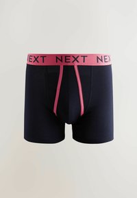 Boxers pour hommes bleu marine avec une ceinture élastique rose portant le nom de la marque "NEXT" en noir. Tissu lisse et extensible avec une coupe ajustée.