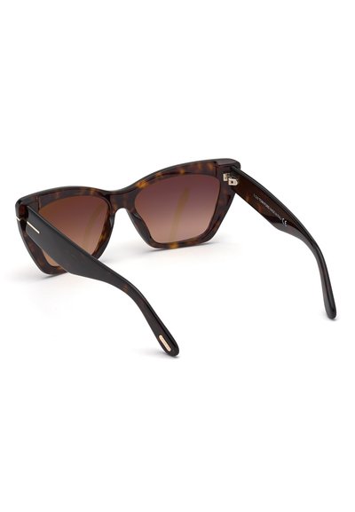Gafas de sol de carey con forma de ojo de gato, lentes marrones degradados y elegantes brazos negros. Presentan detalles en oro en las patillas.