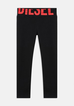 Leggings noirs ajustés avec une large ceinture arborant un grand lettrage rouge "DIESEL" sur le devant.