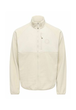 Veste en polaire couleur crème avec fermeture éclair intégrale à l'avant, col montant, poche zippée sur la poitrine et logo discret sur la partie supérieure gauche de la poitrine.