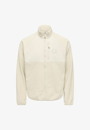 Veste en polaire couleur crème avec fermeture éclair intégrale à l'avant, col montant, poche zippée sur la poitrine et logo discret sur la partie supérieure gauche de la poitrine.