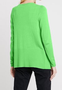 Green knit sweater with a round neckline, ribbed texture at the hem, and long sleeves. Casual fit, lightweight, and smooth fabric.