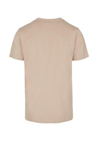 Kortermet t-skjorte i lys beige, laget av myk bomull. Har rund hals og et enkelt, sømløst design uten grafikk eller mønstre.