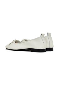 Bailarinas de cuero blanco con un acabado texturizado, que presentan un detalle de lazo en la parte frontal y un tacón negro bajo para mayor estabilidad.