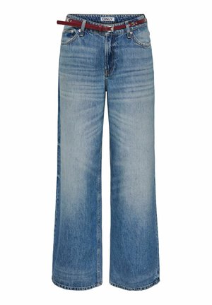 Széles szárú kék farmernadrág elszíneződött részletekkel és egy vékony piros bőr övvel, amely át van fűzve a derékrészen.