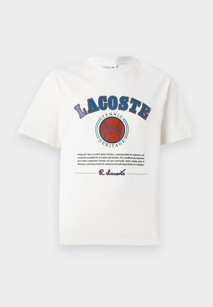 Witte katoenen t-shirt met blauwe en rode grafische tekst, illustraties en een logo op de voorkant, met een ronde halslijn en korte mouwen.