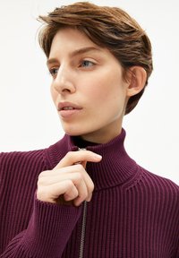 Burgunderfarbener gerippter Pullover mit hohem Kragen und Reißverschluss. Verfügt über lange Ärmel und ein strukturiertes Design mit eng anliegender Passform.