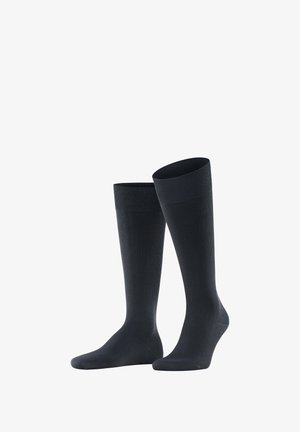 Calze nere fino al ginocchio realizzate in materiale liscio, con una parte superiore a coste per il comfort. Colore uniforme senza motivi o accessori.