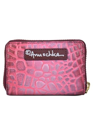 Textured pink leather wallet with a crocodile pattern, featuring a brown label with white text and gold zipper hardware.