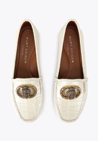 Roomkleurige loafers met een krokodillenleerstructuur, voorzien van een metallic siergesp en bruine binnenzolen. Rond neusje en instapmodel.