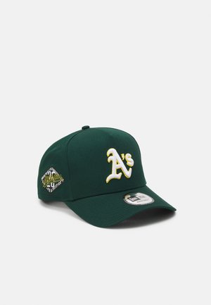 Grüne Baseballmütze mit aufgesticktem weißen und gelben "A's"-Logo. Verfügt über eine strukturierte Form und einen gebogenen Schirm mit einem Markenaufkleber.