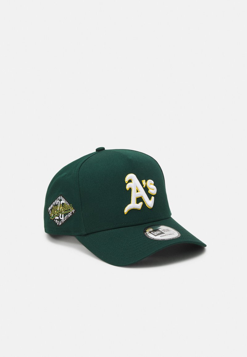 Gorra de béisbol verde con el logo bordado "A's" en blanco y amarillo. Presenta una forma estructurada y una visera curvada con una etiqueta de marca.