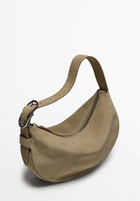 Hobo taske i blød beige ruskind med en buet form, justerbar rem med en metalring og en lynlåslukning for sikker lukning.