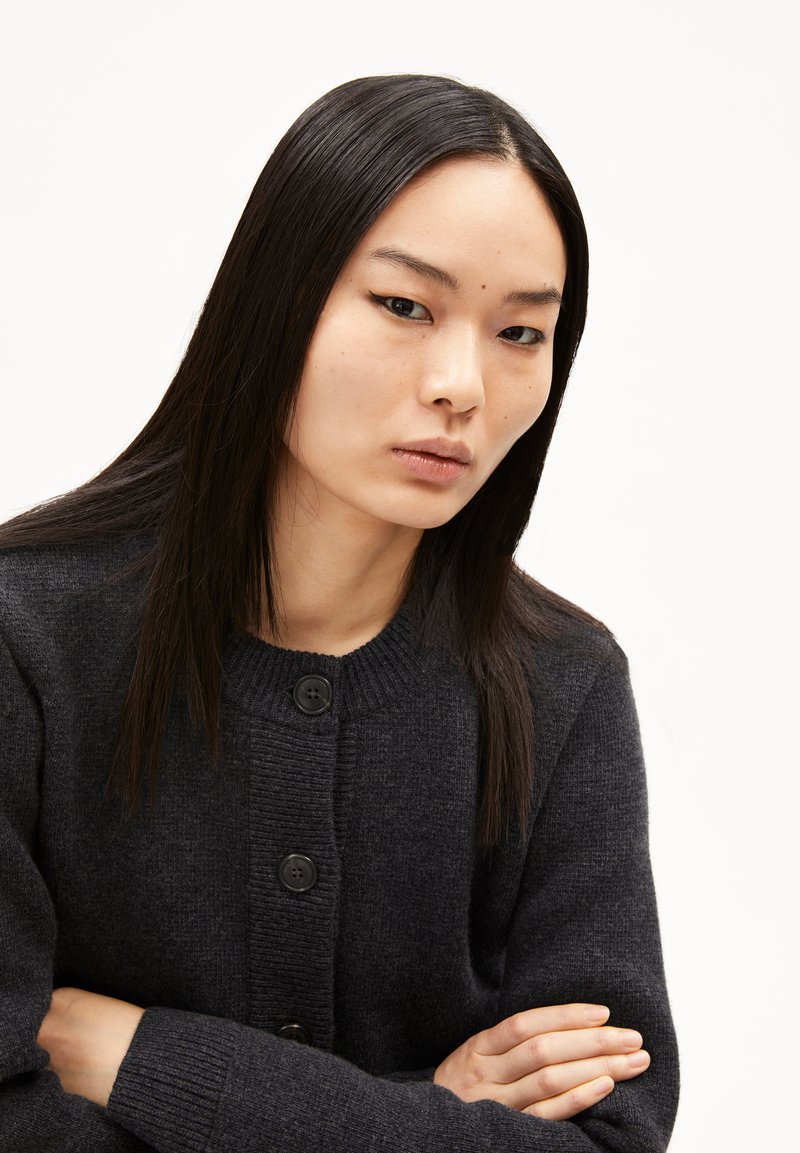 Dunkelgrauer Cardigan mit geripptem Kragen und Knopfverschluss, langen Ärmeln und einem weichen, strukturierten Stoff.