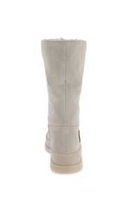 Botas altas de ante gris claro con forro de pelo sintético en la parte superior, una superficie texturizada y suela de goma. Costuras visibles en los laterales.