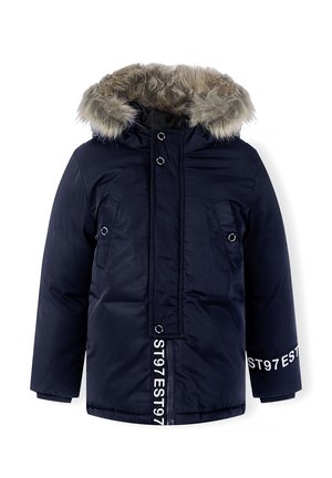 Parka imperméable bleu marine avec capuche en fausse fourrure, deux poches avant et un texte blanc marqué le long de la fermeture éclair et de la manche.