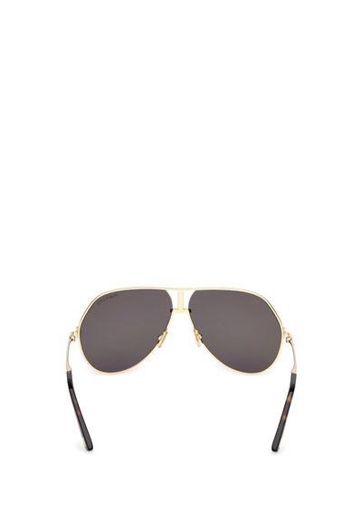 Zlaté aviator sluneční brýle s tmavě šedými skly, tenkým metalovým rámem, acetátovými spánkovými konci se vzorem želvy a nastavitelnými nosními podložkami.