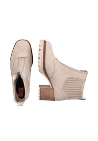 Beige ankle boots with a textured heel, side zipper, elastic panel, and smooth leather upper. Features a rounded toe and ribbed accents.
