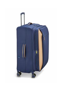 Maleta con ruedas de color azul marino, con una superficie texturizada, detalles en color arena, doble cremallera, bolsillo frontal y cuatro ruedas giratorias para facilitar la movilidad.