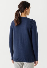 Maglioncino blu navy a maglia con orlo a costine e dettagli sulle spalle, caratterizzato da una vestibilità rilassata. Tessuto testurizzato, maniche lunghe e design semplice.