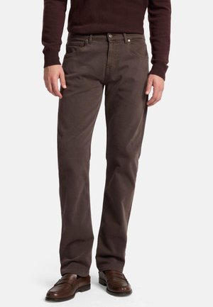 Brown cotton jeans with a straight leg design, five pockets, button closure, and light whiskering detail, paired with brown slip-on shoes.