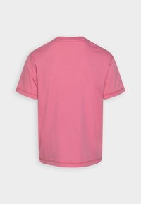 En enfärgad rosa t-shirt med korta ärmar sedd bakifrån, med synliga sömmar på ärmarna och nederkanten mot en vit bakgrund.
