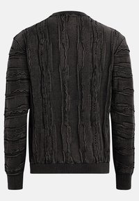 Black sweater with textured pattern, featuring raised lines and zigzag designs. Ribbed collar and cuffs, soft fabric, modern fit.