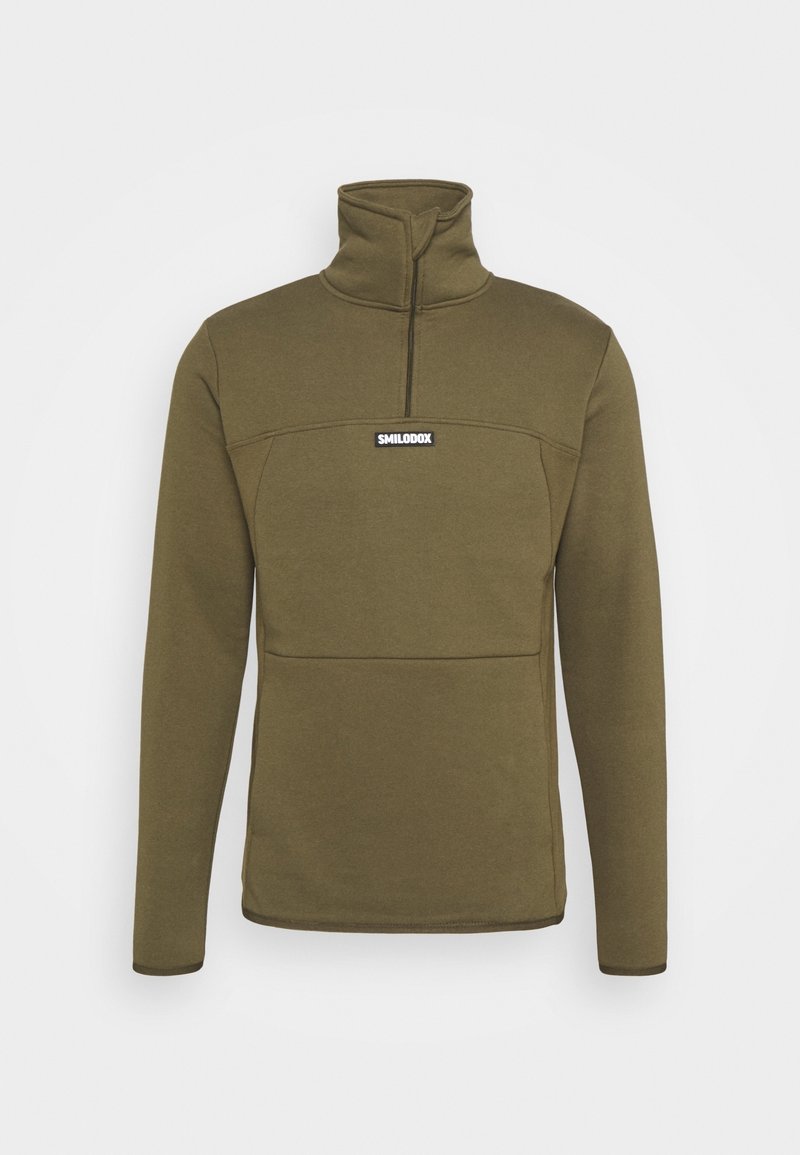 Pull polaire vert olive avec un col montant, une fermeture éclair quart de longueur et une poche avant ; présente un logo noir sur la poitrine. Texture lisse.