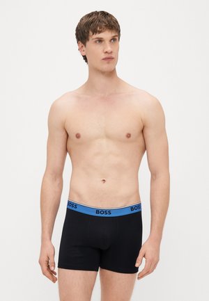 Boxers pretos com uma cintura azul que apresenta o logo "BOSS". Os boxers têm um design ajustado e tecido liso e elástico.