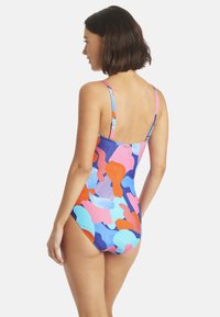 Maillot de bain une pièce multicolore avec des formes abstraites dans des teintes de rose, bleu, orange et violet ; fines bretelles réglables.