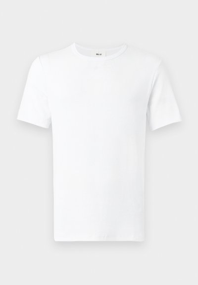 Απλό λευκό t-shirt με κοντά μανίκια και στρογγυλή λαιμόκοψη, εμφανίζεται από μπροστά με ορατή ετικέτα στον λαιμό, σε ανοιχτό φόντο.