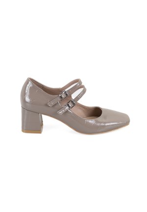 Talons Mary Jane en cuir verni beige avec un bout carré, deux boucles de sangle ajustables et un talon carré texturé.