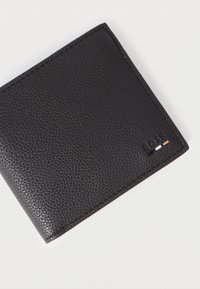 Portofel negru din piele cu suprafață texturată, având un logo de brand discret embossat și dungi decorative colorate în nuanțe deschise și închise.