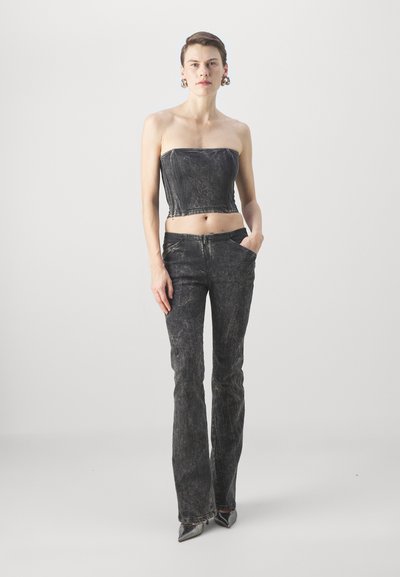 Black denim strapless top with structured seams paired with flared black denim pants. Smooth texture, minimal detailing, and fitted silhouette.