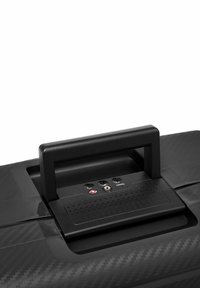 Zwarte carbonvezel koffer met een platte handgreep, voorzien van drie poorten en een gestructureerde oppervlakte. Gladde textuur en strakke designelementen.