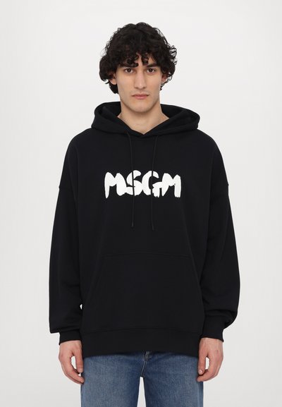 Hoodie noir en mélange de coton, avec un logo "MSGM" blanc dans une police en gras et en coup de pinceau, et une capuche avec cordon de serrage. Coupe regular.