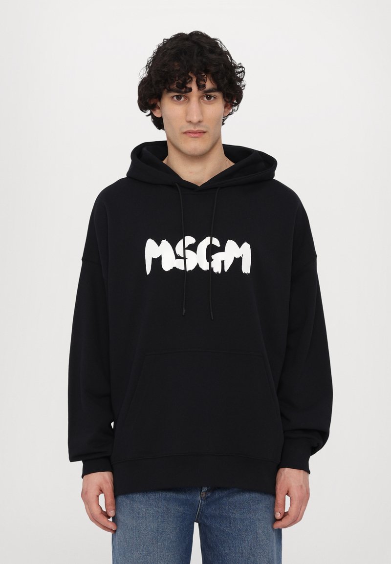 Felpa nera in misto cotone, con logo "MSGM" bianco in un audace carattere a pennellate e cappuccio con coulisse. Vestibilità regolare.
