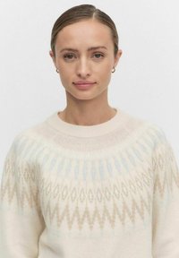 Lichtgekleurde trui met een ronde halslijn, met een geometrisch patroon in beige en lichtblauwe tinten. Zachte gebreide textuur.