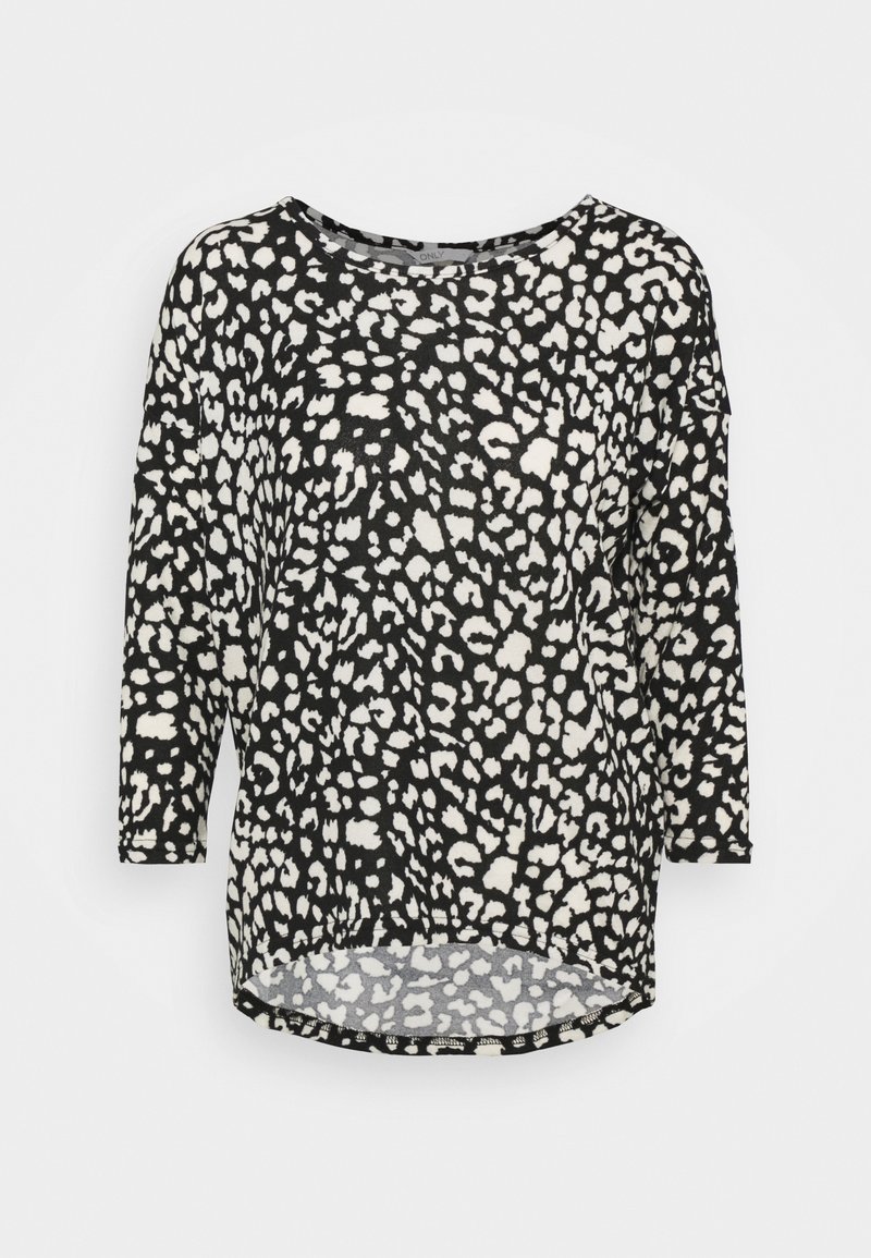 Haut à manches longues noir et blanc avec un motif léopard, encolure ronde et design à ourlet arrondi pour plus de style. Texture de tissu douce.