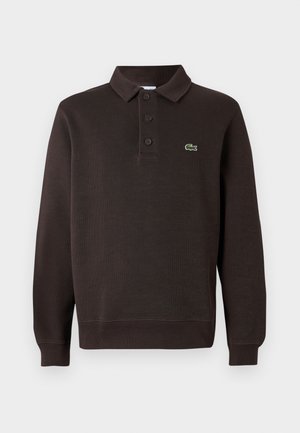 Braunes Langarm-Poloshirt aus strukturiertem Stoff, mit einer Knopfleiste mit drei Knöpfen und einem kleinen Lacoste-Logo auf der Brust.
