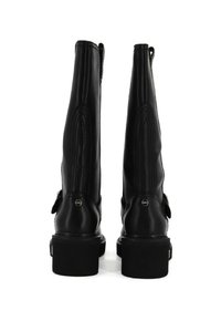 Une paire de bottes noires en cuir hautes avec des talons blocs, vues de l'arrière sur fond blanc.