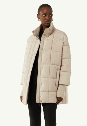 Veste matelassée beige avec un col haut, fermeture éclair sur le devant et boutons-pression. Texture lisse, coupe oversize et poignets côtelés.