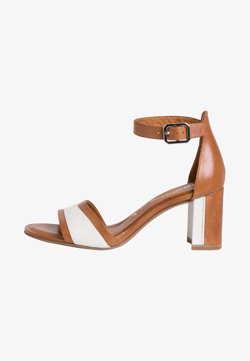 Sandale à bout ouvert en cuir marron et blanc avec bride à la cheville, boucle argentée et talon épais sur fond blanc.