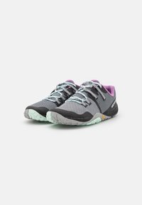 Zapatillas deportivas de malla gris con detalles en negro y lavanda, que cuentan con una suela texturizada, cordones con estampado y un logo reflectante en el costado.