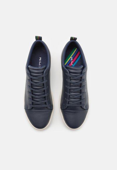 Navy blue leather sneakers with a smooth texture, round toe, and contrasting grey rubber sole. Features flat laces and a colorful stripe on the tongue.