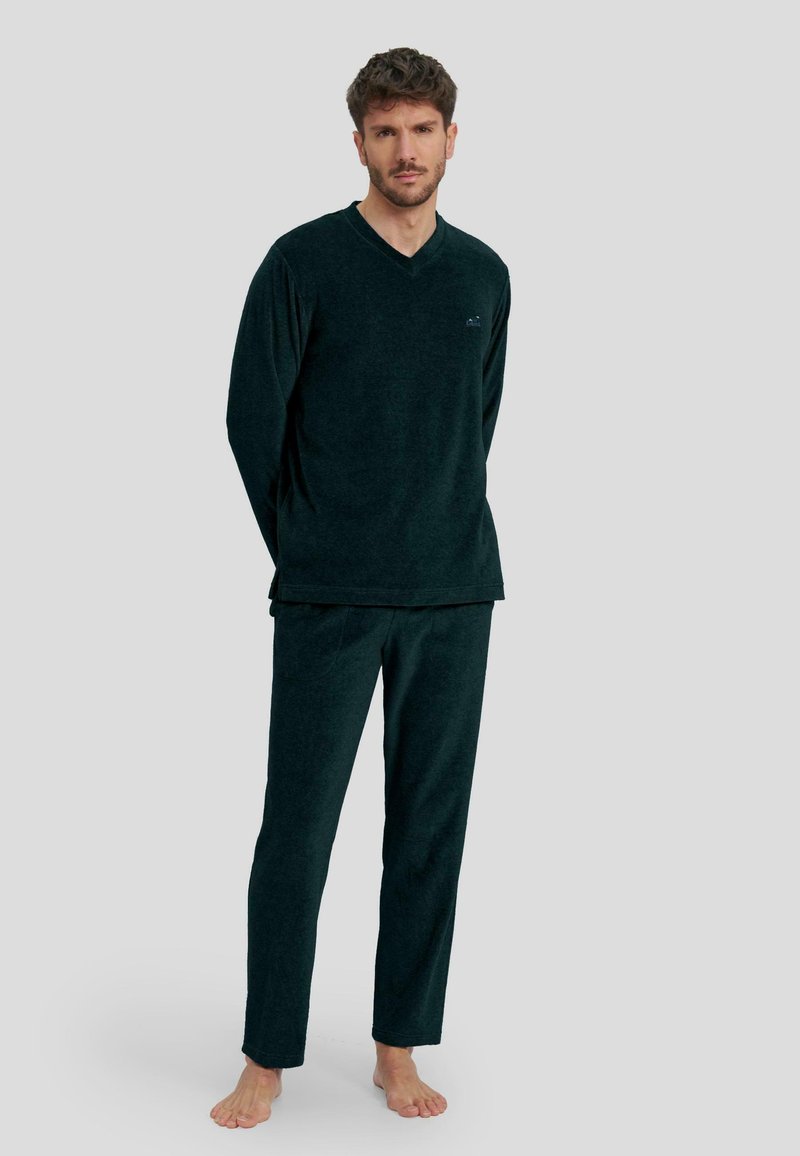 Conjunto de loungewear en verde oscuro hecho de tejido suave, que incluye una parte superior de manga larga con escote en V y pantalones a juego de corte relajado sin patrones visibles.