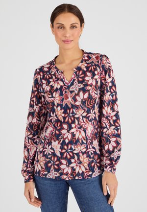 Blusa de manga larga en un tejido azul marino con estampados florales en rojo, rosa y blanco. Presenta un escote en V y detalles fruncidos en los hombros.