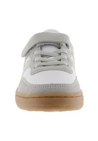 Zapatilla deportiva gris y blanca con cierre de cordones y velcro, parte superior de ante y sintético, suela de goma y acentos texturizados.