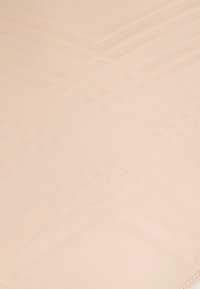 Tecido nu sem emendas com uma textura suave, apresentando um padrão geométrico sutil e um brilho suave. Construído com costuras mínimas para conforto.